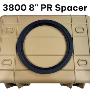 May include: A tan rectangular hard-shell case with a black circular spacer centered on the lid. The text 3800 8" PR Spacer is printed in black above the case. The case features a grid-like molded design with four oval indentations on the lid.