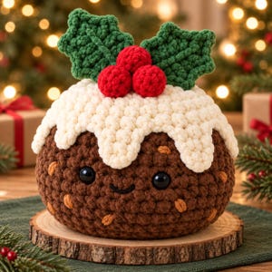 May include: A round, brown crocheted Christmas pudding plush with a white crocheted icing top, three red crocheted berries, and two green crocheted holly leaves. The pudding features two black plastic safety eyes and a stitched smile.