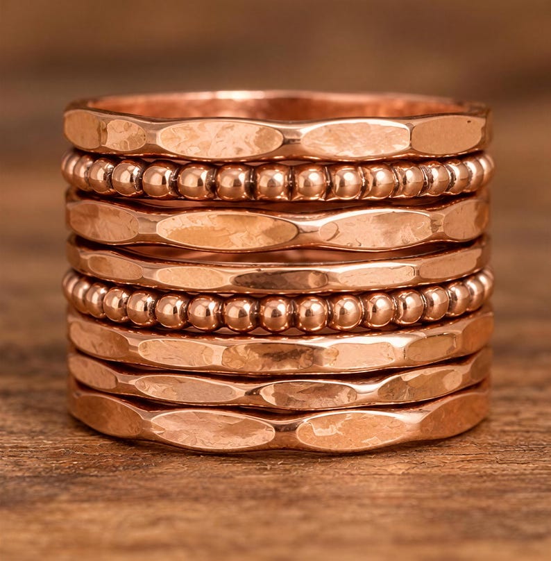 A stack of copper-colored rings with a textured, engraved appearance.