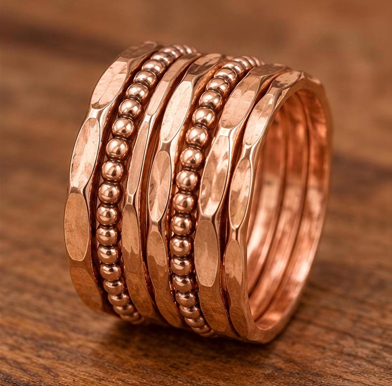 A close-up image of a stack of copper-colored rings with a textured, metallic appearance.