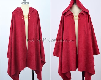 May include: A red hooded cloak with a textured surface, displayed on a mannequin. The cloak has a gold clasp closure at the neckline and a flowing design. The text "Bad Wolf Costumes.com" is visible.