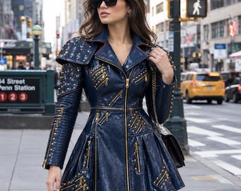 May include: A dark blue, textured, long-sleeved jacket with a flared skirt hem, featuring gold-toned metal studs, multiple diagonal zippered pockets, and a full-length front zipper. The garment has structured shoulders and a wide collar.
