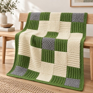 May include: A knitted blanket featuring a checkered pattern of square blocks in cream, forest green, and grey. The design alternates between smooth ribbed textures and raised bumpy stitch patterns, creating a tactile surface across the entire throw.