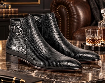Zwarte heren enkellaarsjes van leer met pythonprint, nette schoenen met gesp en leren zool.