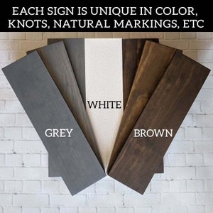 May include: Close-up of five wood samples in different colors: grey, white, brown, and two shades of brown. The wood samples are arranged in a fan shape with the text "WHITE", "GREY", and "BROWN" printed below each sample.