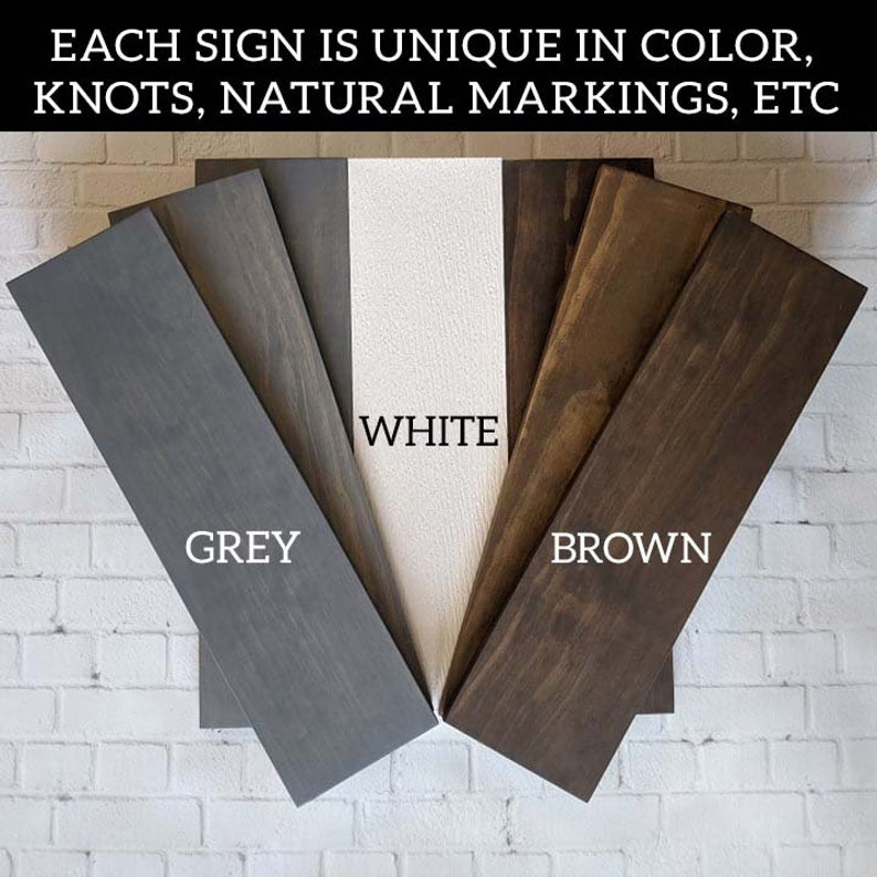 May include: Close-up of five wood samples in different colors: grey, white, brown, and two shades of brown. The wood samples are arranged in a fan shape with the text "WHITE", "GREY", and "BROWN" printed below each sample.