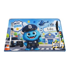 Peut inclure: Un set de table rectangulaire illustré d'un monstre bleu en uniforme de policier, une voiture de police, un hélicoptère et un commissariat. Le texte indique PETIT HÉROS, Léo, POLICE et MISSION BON APPÉTIT. Une fourchette et un couteau sont posés.
