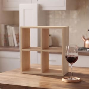 Può includere: Un'unità a scaffale quadrata in legno chiaro dotata di quattro scomparti uguali disposti in una griglia due per due. Lo scaffale presenta una finitura liscia con venature del legno naturali e una struttura semplice a telaio aperto.