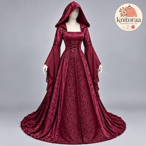 May include: A floor-length burgundy dress featuring a hood, long flared sleeves, and a corset-style lace-up bodice. The fabric displays a tonal floral damask pattern. A circular logo in the top right corner contains the text knitoraa handmade with love.