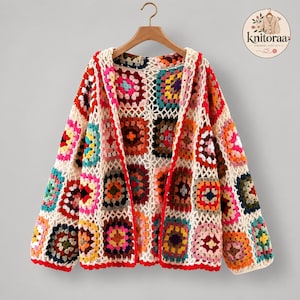 Peut inclure: Un gilet à manches longues composé de carrés de crochet multicolores assemblés par un motif en treillis blanc. Le vêtement présente une gamme vibrante de carrés dans des tons de rouge, rose, bleu, jaune et orange, avec une bordure rouge.