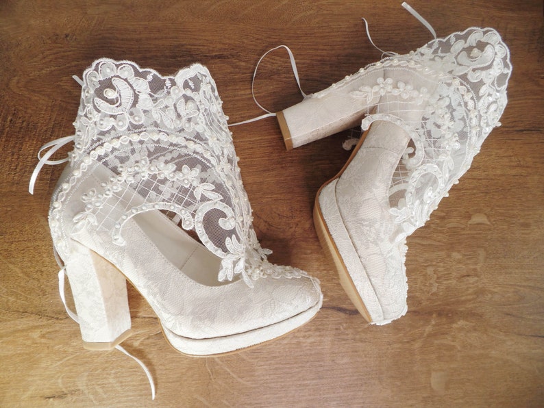 Ivory lace wedding boots with pearl and bead embroidery. Floral lace bridal shoes with block heels.