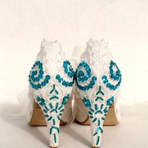 Teal sequins and beads embroidered on the heels of ivory lace wedding shoes.