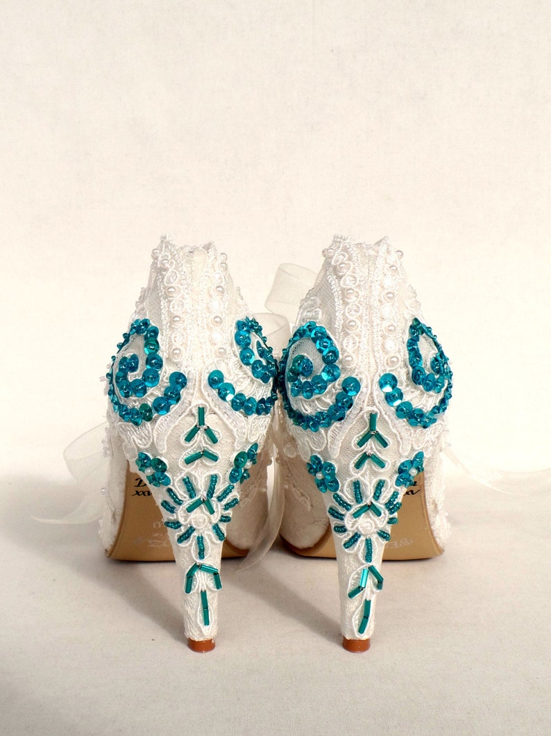 Teal sequins and beads embroidered on the heels of ivory lace wedding shoes.