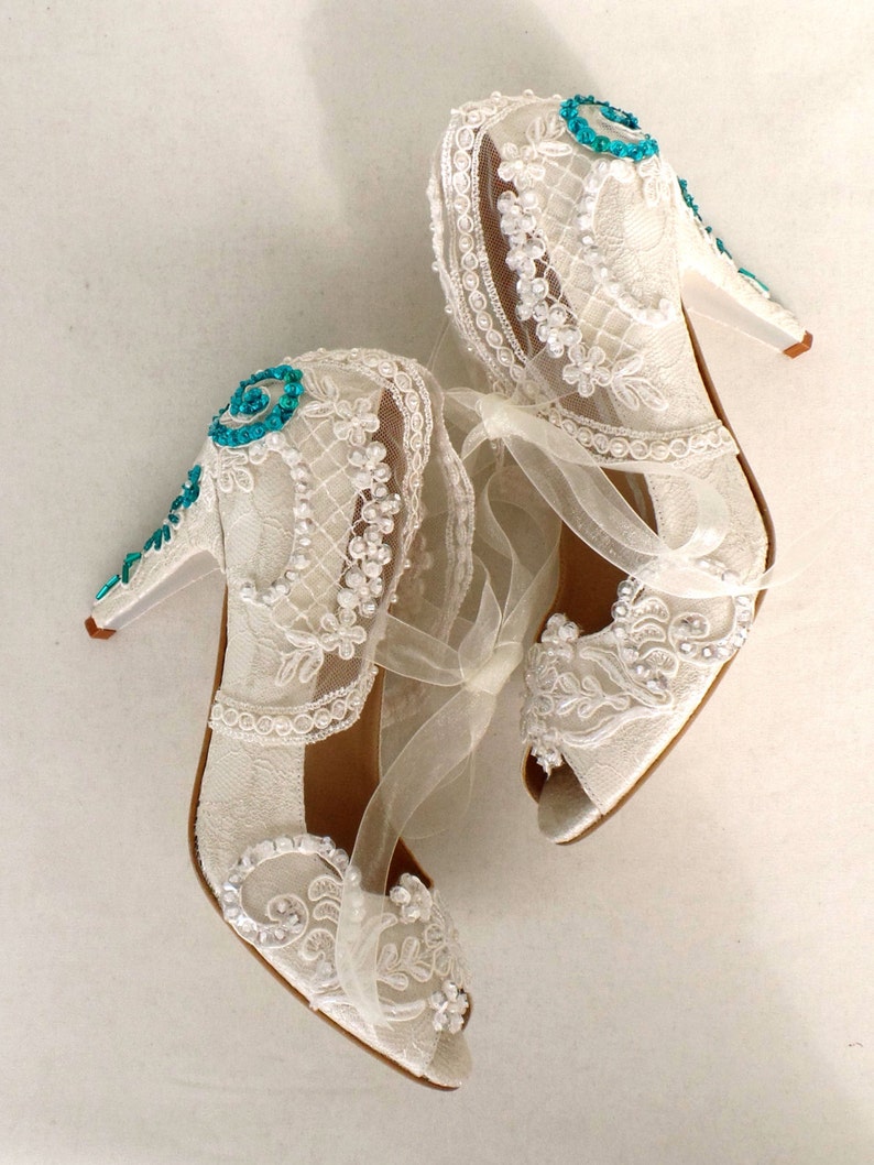 Floral lace bridal shoes with teal beadwork on the heels. Elegant wedding shoes for teal weddings.