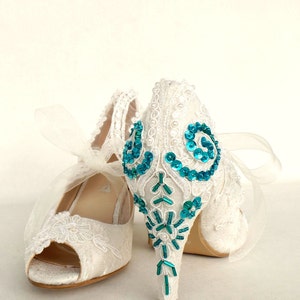 Teal embroidery on the heels of ivory lace wedding shoes.