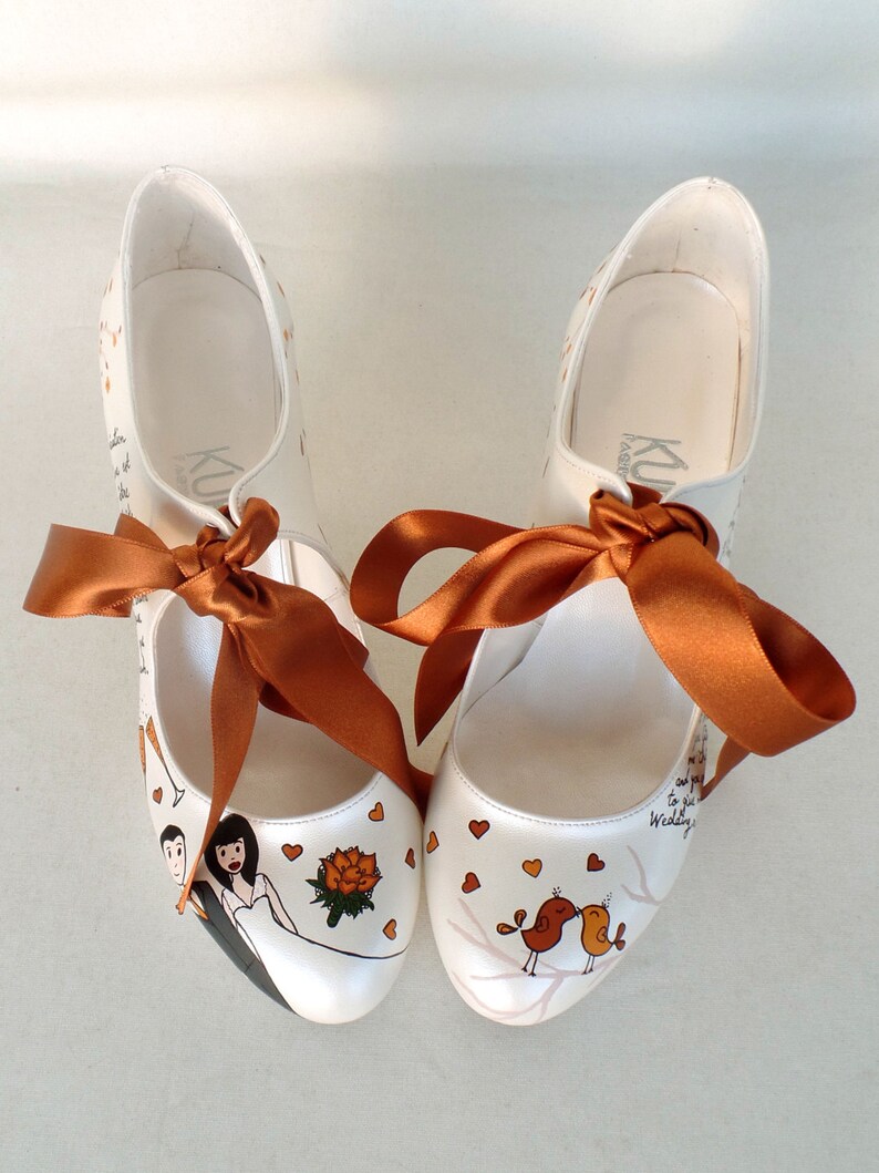 personalized bridal shoes with burnt orange ribbons, love birds, bride and groom and flower painting on the front.