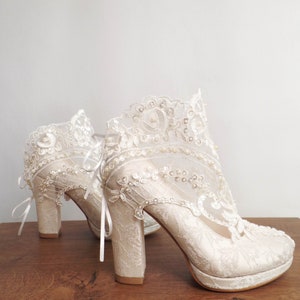 Ivory lace wedding boots with pearl and bead embroidery. Floral lace bridal shoes with block heels.