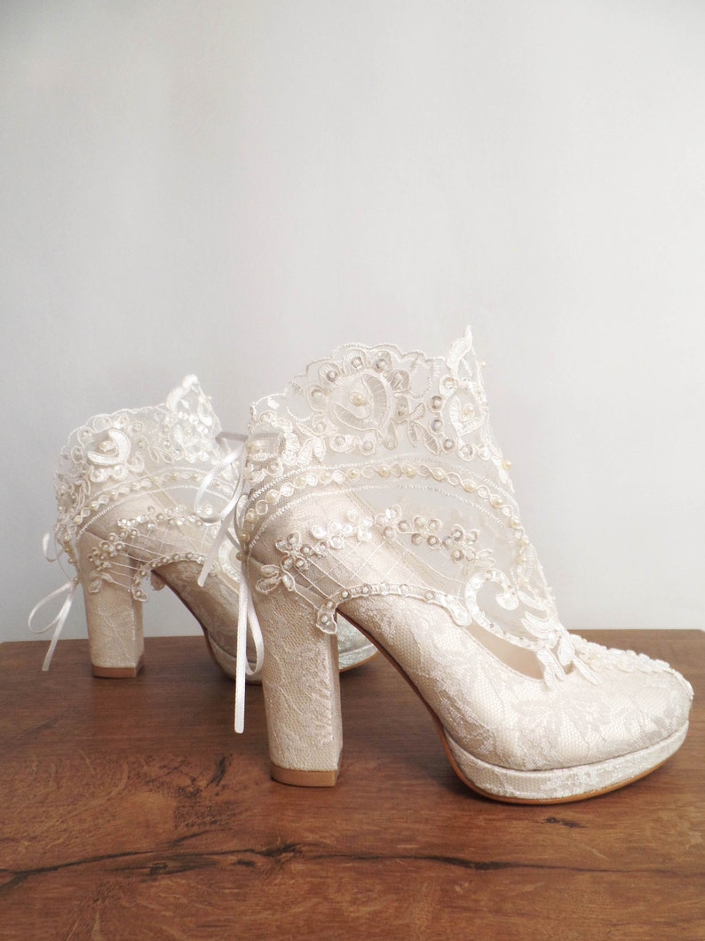 Ivory lace wedding boots with pearl and bead embroidery. Floral lace bridal shoes with block heels.