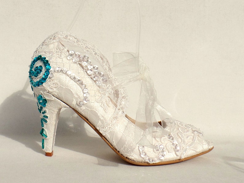 Floral lace beaded bridal shoe with teal accent color on the heels.