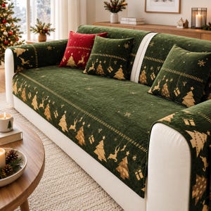 May include: A dark green sofa cover featuring a gold-toned pattern of Christmas trees, reindeer, gift boxes, and snowflakes. The set includes matching square throw pillows, with one solid red pillow, all displayed on a white upholstered sofa.