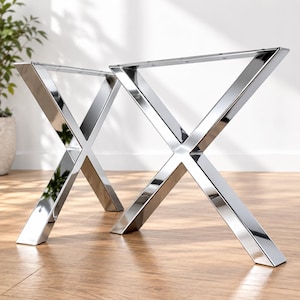 Puede incluir: Dos patas de mesa en forma de X hechas de metal cromado pulido. Cada pata presenta un diseño de marco cruzado con una placa de montaje horizontal plana en la parte superior, que contiene orificios pretaladrados para su fijación.