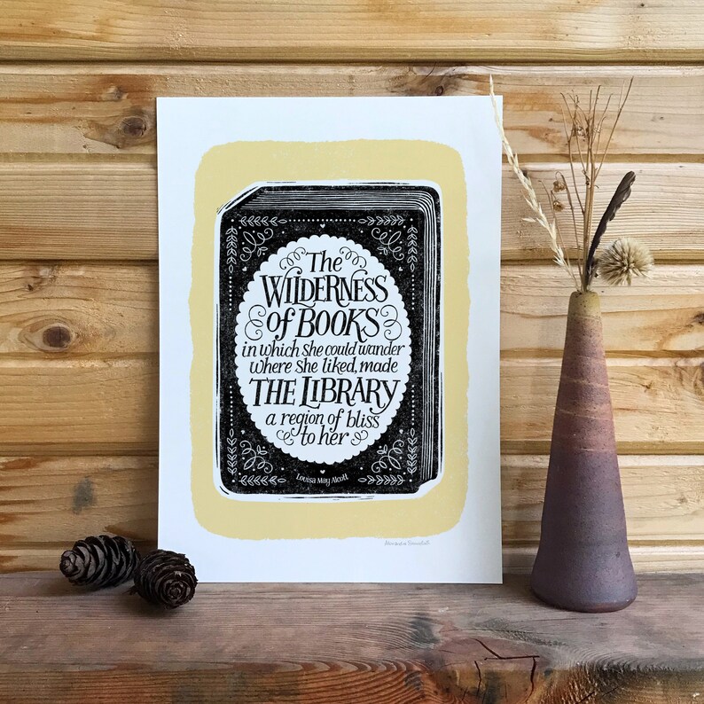 May include: A black and white print with a yellow background featuring a quote about books and libraries. The quote reads "The Wilderness of Books in which she could wander where she liked, made The Library a region of bliss to her."