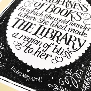 May include: Black and white typography print with a quote about books and libraries by Louisa May Alcott. The quote reads "& of BOOKS? in which she could wander where she liked, made THE LIBRARY a region of bliss to her."