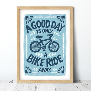 May include: A blue and white poster with a vintage style design. It features a bicycle and the text "A good day is only a bike ride away".