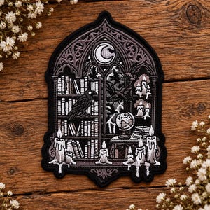 May include: A gothic-style embroidered patch featuring a library scene with a crescent moon, a raven perched on a bookshelf, a globe, and multiple melting candles. The design is rendered in shades of black, grey, and white with intricate stitching.