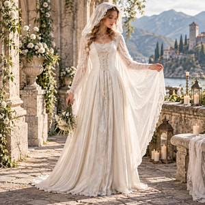 May include: A floor-length ivory gown featuring a lace-up bodice, long flowing sleeves, and an attached hood. The dress is crafted with a combination of satin-like fabric and intricate lace overlays, creating a layered appearance with a full skirt.