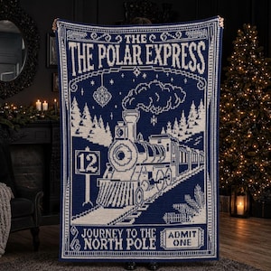 Könnte beinhalten: Eine rechteckige, marineblaue und cremefarbene Häkeldecke mit einer detaillierten Zug-Grafik. Der Text lautet THE POLAR EXPRESS, JOURNEY TO THE NORTH POLE und ADMIT ONE, mit einem Schild, das die Nummer 12 zeigt. Das Design enthält Tannenbäume.