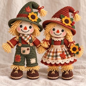 Puede incluir: Dos muñecos espantapájaros de ganchillo con pelo de lana, sombreros puntiagudos con girasoles y ropa de otoño. El muñeco de la izquierda lleva un peto verde con parches, mientras que el de la derecha viste un vestido de cuadros con delantal.