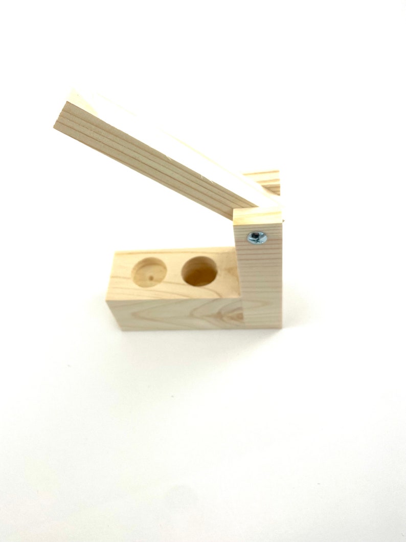 May include: A wooden box with two holes in the top and a hinged lid. The box is made of light wood and has a natural finish.