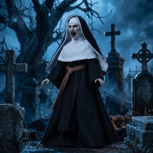 Könnte beinhalten: Eine Sammler-Actionfigur einer Nonne mit blasser Haut, spitzen Zähnen und dunklen Augen. Die Figur trägt eine traditionelle schwarz-weiße Tracht mit einer langen, dunkelbraunen Schärpe um die Taille und steht in einer dunklen Friedhofskulisse.