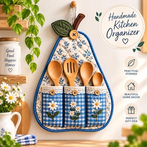 Può includere: Un organizer da cucina in tessuto a forma di pera con motivo floreale blu e bianco, dotato di tre tasche in tessuto vichy blu e applicazioni a margherita bianche. Contiene quattro cucchiai di legno e riporta il testo Handmade Kitchen Organizer.