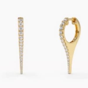 May include: A pair of gold hoop earrings with a pointed tip. The hoops are set with small, clear diamonds.