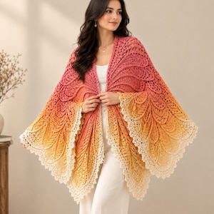 Puede incluir: Un chal de ganchillo con un patrón de colores degradados que transita de rosa intenso en la parte superior a naranja y amarillo, terminando en un borde festoneado color crema. La prenda tiene un patrón de puntos detallado en forma de hoja.