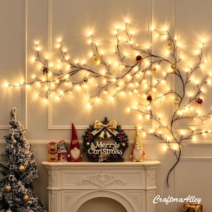 Pode incluir: Um ramo decorativo de parede com luzes LED brancas quentes e ornamentos pendurados. Na lareira, uma guirlanda com o texto Merry Christmas, duas figuras de gnomos e pequenas caixas de presente. Uma árvore de Natal flocada está ao lado.