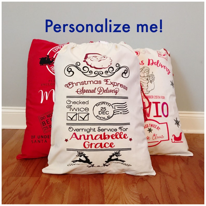 May include: White canvas Christmas gift bag with a red and black design. The bag has a Santa Claus graphic, the text "Christmas Express - Special Delivery", and the text "Overnight Service For Annabelle Grace".