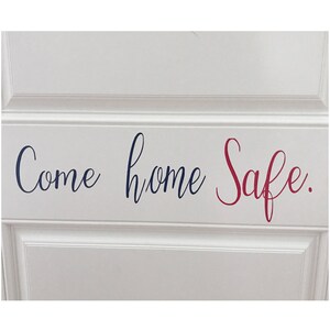May include: A white door with a navy blue and red vinyl decal that reads "Come home Safe."