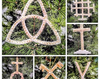 May include: A collage of Christmas tree ornaments. The ornaments include a white and gold Trinity knot, a Jerusalem cross, a cross, a cross with a circle, crossed keys, and a Y-shaped ornament. All are decorated with gold and white accents.
