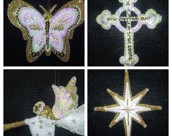 Könnte beinhalten: Vier Weihnachtsschmuckstücke: ein Schmetterling, ein Kreuz, ein Engel und ein Stern. Der Schmetterling hat goldene Glitzerkanten und schillernde Pailletten. Das Kreuz, der Engel und der Stern weisen ebenfalls goldene Glitzer und schillernde Pailletten auf.