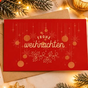Può includere: Un biglietto d'auguri rettangolare rosso con il testo dorato "FROHE weihnachten" centrato sul davanti. Il design presenta illustrazioni dorate di ornamenti appesi, fiocchi di neve, stelle e foglie di agrifoglio in un motivo festivo.