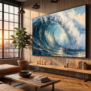 May include: A large rectangular wall art piece featuring an oil painting of a crashing ocean wave in shades of deep blue, turquoise, and white. The artwork is displayed on a wood-paneled wall above a long wooden console table with candles and books.