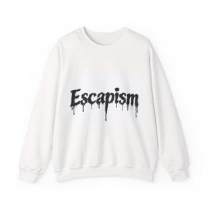 Peut inclure: Un sweat-shirt blanc à manches longues et col rond avec le mot Escapism imprimé en noir sur la poitrine. Le lettrage présente un effet de peinture dégoulinante, avec des traînées d'encre verticales descendant du bas de chaque lettre.