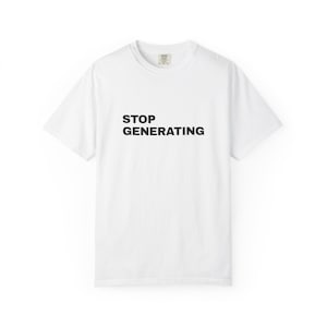 May include: A white short-sleeved crew neck t-shirt featuring the black text STOP GENERATING printed in a bold, sans-serif font across the centre of the chest. The garment has a standard fit with a ribbed collar and a visible brand label at the neck.