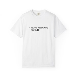 Peut inclure: Un t-shirt blanc à manches courtes avec un texte noir imprimé sur la poitrine qui indique : > You're Absolutely Right. suivi d'un petit symbole de curseur carré noir. Le vêtement possède une encolure ronde et une coupe standard.
