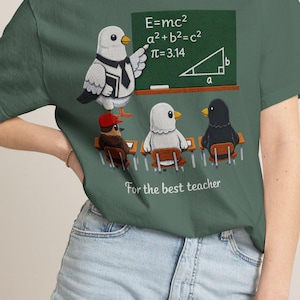 May include: A dark green t-shirt featuring a graphic of a pigeon teacher in a tie standing at a chalkboard with math equations, teaching three smaller birds sitting at desks. The text "For the best teacher" is printed below the graphic.