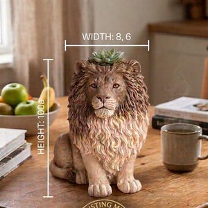 Op de afbeelding: Een bruin en beige leeuwenfiguur met een textuurrijke manen en een kleine groene vetplant op de kop. Het figuur bevat tekstlabels met een breedte van 8,6 cm en een hoogte van 100a, en een logo met de tekst THE DUSTING METHOD LION KING FIGURE.