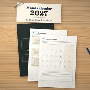 K&ouml;nnte beinhalten: Ein 2027 Mondkalender als druckbares PDF-Set mit einem dunklen Deckblatt und wei&szlig;en Innenseiten, die Monats&uuml;bersichten, Mondphasensymbole und deutschen Text wie "Mondkalender 2027" und "Hartung, auch Eismond" sowie einen blauen Stift zeigen.
